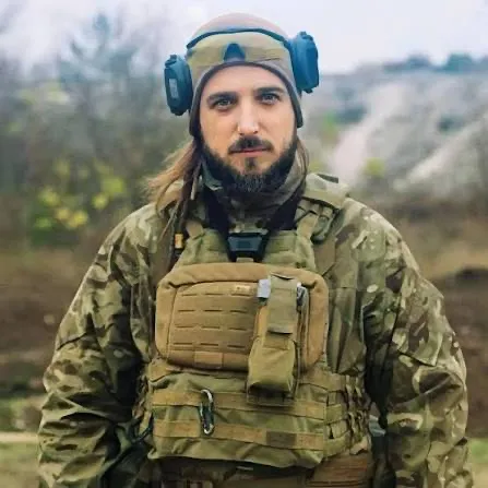 Максим Кривцов у військовому спорядженні й навушниках
